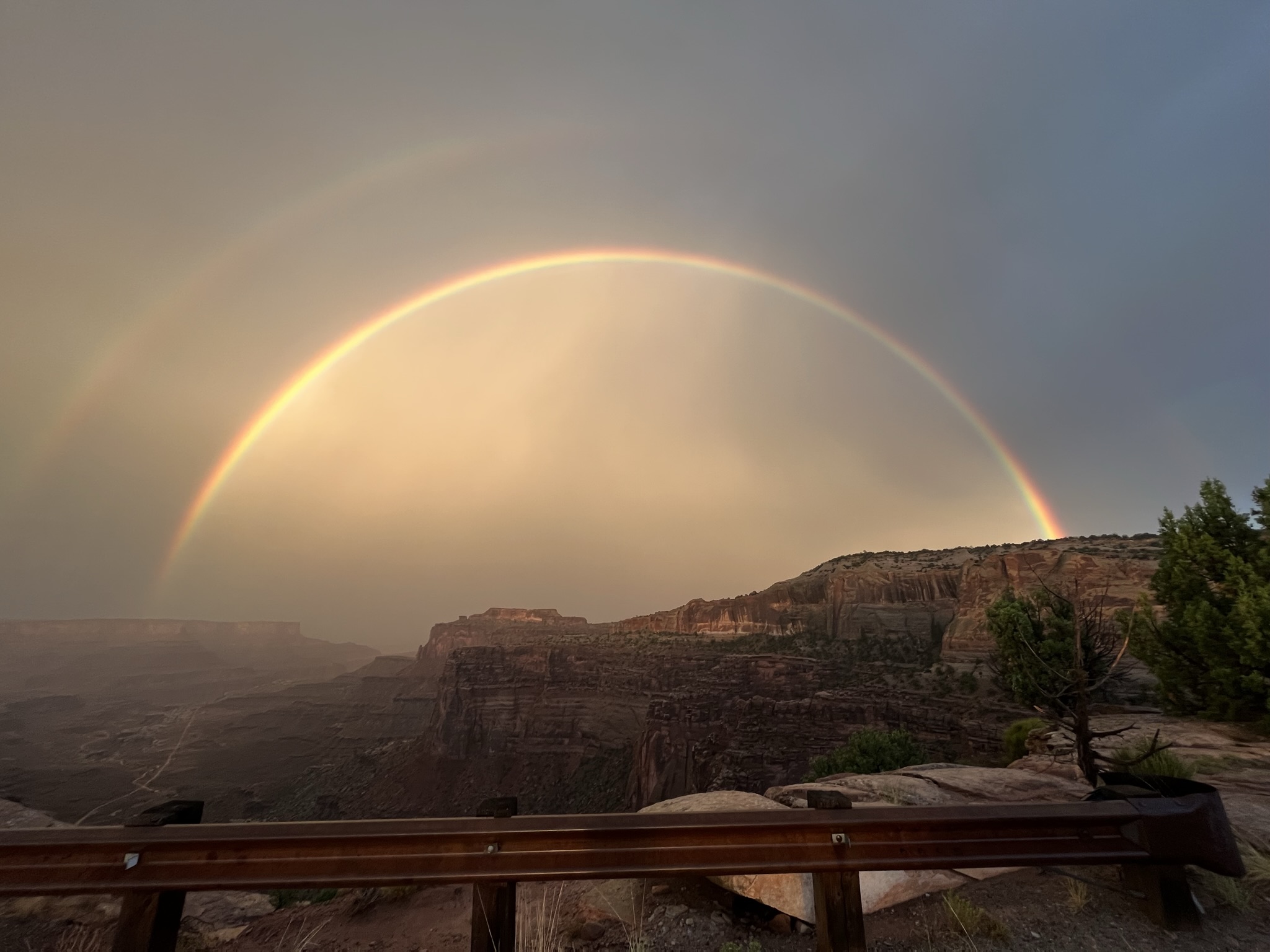 A photo of a double rainbow over a canyon